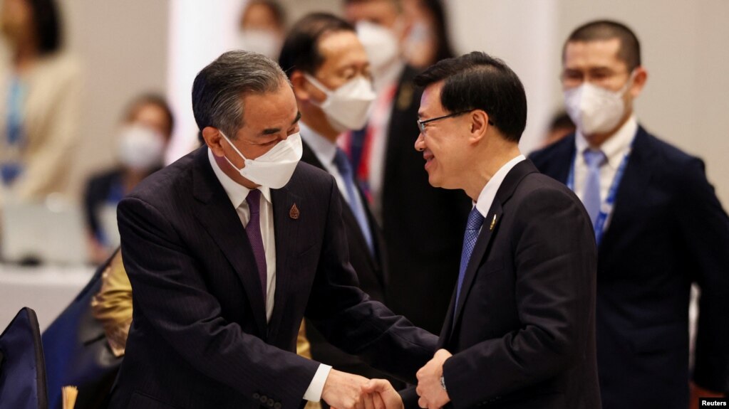 香港特首李家超2022年11月18日在出席亚太经合组织峰会期间与中国外长王毅握手。（路透社）(photo:VOA)