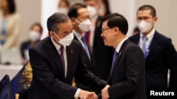 香港特首李家超2022年11月18日在出席亚太经合组织峰会期间与中国外长王毅握手。（路透社）