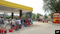 Residents wait in line with gas cans at a Gas Plus gas station in the aftermath of Hurricane Helene, Sept. 29, 2024, in North Augusta, South Carolina. 