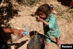 Asia, 4, whose mother has died, washes her face, next to family destroyed house, in the aftermath of a deadly earthquake, in Tikekhte, near Adassil, Morocco, September 11, 2023. (REUTERS/Nacho Doce)