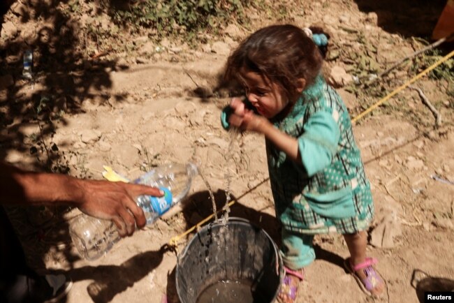 Asia, 4, whose mother has died, washes her face, next to family destroyed house, in the aftermath of a deadly earthquake, in Tikekhte, near Adassil, Morocco, September 11, 2023. (REUTERS/Nacho Doce)