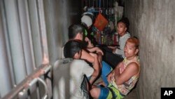 In this April 27, 2017 photo, detainees crouch on the floor inside a secret jail after being discovered by the Commission on Human Rights at Police Station 1 at Tondo district in Manila, Philippines. 