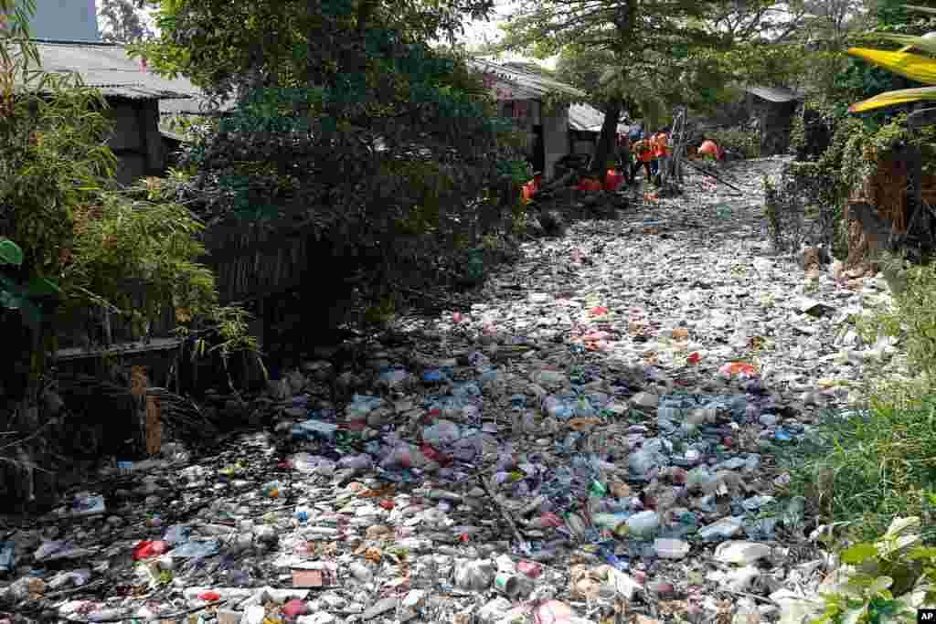 Workers collect trash during a clean-up of the Bahagia River in Bekasi, Indonesia.