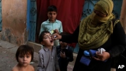 FILE - A Pakistani health worker gives a polio vaccine to a child in Karachi, Pakistan, Dec. 1, 2016. Polio remains endemic in Pakistan after the Taliban banned vaccinations, instigated attacks targeting medical staffers and spread suspicions about the vaccine.