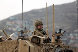 FILE - A British soldier with NATO-led Resolute Support Mission forces arrives at the site of an attack in Kabul, Afghanistan, March 25, 2020.