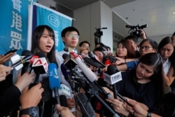 Pro-democracy activists Agnes Chow, left, and Joshua Wong speak to media outside a district court in Hong Kong, Aug. 30, 2019.