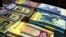 FILE - Iranian and U.S. banknotes are on display at a currency exchange shop in Tehran, April 4, 2015.