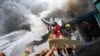 Residents and firefighters carry a Black Nazarene statue from a burning house after a fire hit an informal settlement in Manila, Philippines.