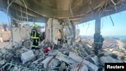 Bahrain civil defence and rescue personnel work in a residential building, which according to the Bahraini Interior Ministry, was hit by an Iranian drone, Muharraq, Bahrain, June 28, 2026.
