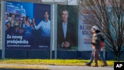 Pedestrians walk past campaign posters of presidential candidates Dragan Primorac and Zoran Milanovic ahead of the presidential election in Zagreb, Croatia, on Dec. 26, 2024.