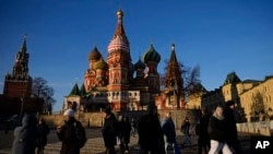 La gente camina por la Plaza Roja junto a la Catedral de San Basilio y la torre Spasskaya del Kremlin en un día soleado en Moscú, Rusia, el martes 26 de noviembre de 2024. AP