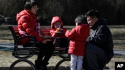 In this Feb. 17, 2019, photo, a couple spend time with their children at a park in Beijing. Facing a future demographic crisis and aging society, China's leaders are desperately seeking to persuade couples to have more children.