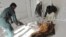 Afghan policemen carry the dead body of a victim at a local hospital after a suicide bomb attack in Khost province, December 26, 2012.