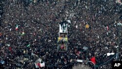 Los ataúdes del general Qassem Soleimani y otros que murieron en Irak en un ataque de EE.UU. con aviones no tripulados, son transportados en un camión rodeado de dolientes en la ciudad de Mashhad, Irán, el domingo 5 de enero de 2020. (Mohammad Hossein Thaghi/Tasnim News Agency)