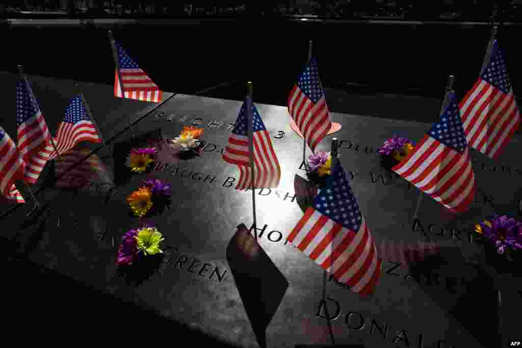 Flowers and U.S. flags are seen on the 9/11 Memorial in New York, Sept. 10, 2022,