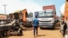FILE - A truck driver from Chad walks between trucks at the border of Garoua-Boulai, Cameroon, Jan. 8, 2021. Hundreds of truckers have stopped transporting goods to and from Chad until Cameroon repairs dilapidated portions of the road, one union official said Sept. 6, 2022. 