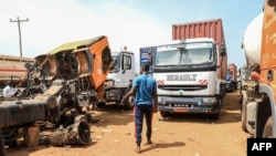 FILE - A truck driver from Chad walks between trucks at the border of Garoua-Boulai, Cameroon, Jan. 8, 2021. 