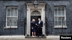 New British Prime Minister Liz Truss and her husband Hugh O'Leary stand outside Downing Street, in London, Sept. 6, 2022.