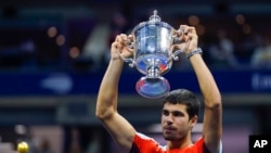 Carlos Alcaraz, of Spain, holds up the championship trophy after defeating Casper Ruud, of Norway, in the men's singles final of the U.S. Open tennis championships, Sunday, Sept. 11, 2022, in New York.