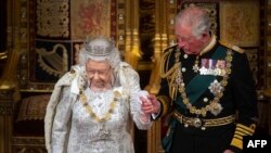 Ratu Elizabeth II didampingi putranya, Pangeran Charles setelah menyampaikan Pidato Ratu pada Pembukaan Parlemen Negara di Gedung Parlemen di London pada 14 Oktober 2019. (Foto: AFP)