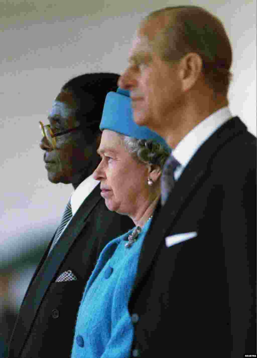 Queen Elizabeth II and the Duke of Edinburgh stand with President of Zimbabwe Robert Mugabe (L) shortly before he reviewed a guard of honour May 17, 1994.