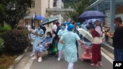 In this photo released by Xinhua News Agency, medical workers transfer patients to safe area at Renmin Hospital of Shimian County in Ya'an City, in the aftermath of an earthquake in southwestern China's Sichuan Province, Monday Sept. 5, 2022. (Xinhua via