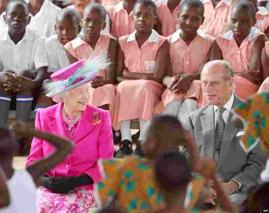 Britain&#39;s Queen Elizabeth II watches a dance performance by school children with her husband Prince Philip (R) during her visit to the Kitante Primary School in Kampala, on the last day of her state visit to Uganda, 24 November 2007