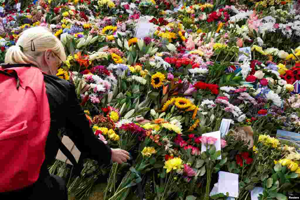 A woman leaves flowers at Hillsborough Castle, following the death of Britain&#39;s Queen Elizabeth, at Royal Hillsborough, Northern Ireland.