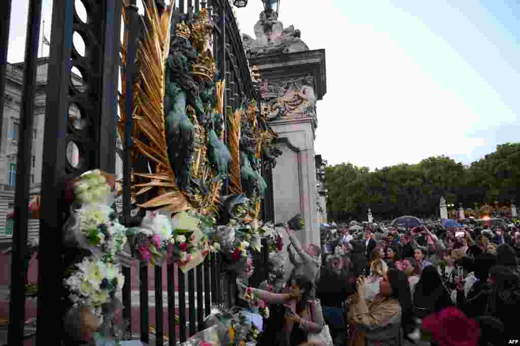 People gather to pay their respects outside of Buckingham Palace, after the announcement of the death of Queen Elizabeth II, in central London on Sept. 8, 2022. 