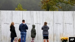 ARCHIVO - Visitantes del Monumento Nacional al Vuelo 93 en Shanksville, Pensilvania, participan en un servicio conmemorativo al atardecer el lunes 10 de septiembre de 2018, cuando la nación conmemora el 17.º aniversario de los ataques del 11 de septiembre de 2001. (Foto AP/Gene J. Puskar)