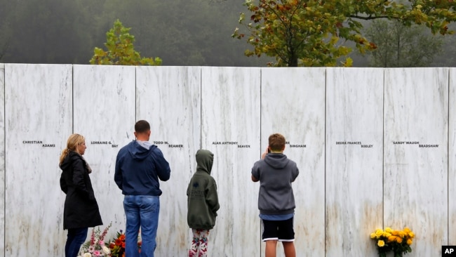 ARCHIVO - Visitantes del Monumento Nacional al Vuelo 93 en Shanksville, Pensilvania, participan en un servicio conmemorativo al atardecer el lunes 10 de septiembre de 2018, cuando la nación conmemora el 17.º aniversario de los ataques del 11 de septiembre de 2001. (Foto AP/Gene J. Puskar)