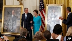 FILE - President Barack Obama applauds former President George W. Bush and former first lady Laura Bush during a ceremony in the East Room of the White House in Washington, May 31, 2012, where the Bush's portraits were unveiled.