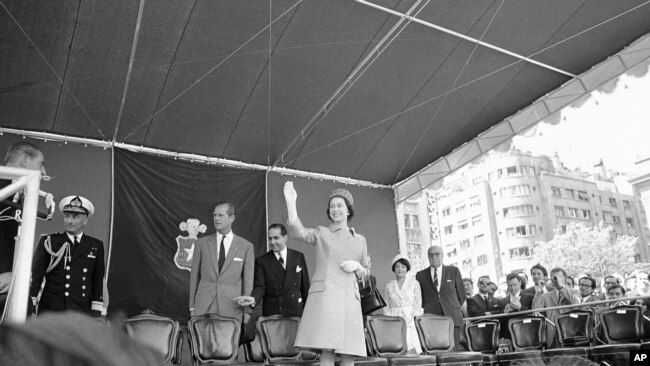 La reina Isabel II saluda desde estrado a la multitud invitada a la Plaza de la Constitución en el centro de Chile, el 11 de noviembre de 1968, para su recibimiento; en el acto recibió las llaves de la ciudad.