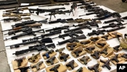 FILE - This June 2022 photo released by the San Jose Police Department shows assault weapons, multiple high-capacity magazines, pistols, and other weapons seized from the home of a homicide suspect.