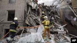 Украинские пожарные работают в разрушенном здании в центре Харькова, Украина, 6 сентября 2022 года.