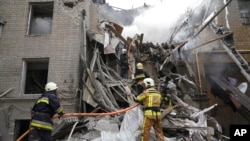 Los bomberos ucranianos trabajan en un edificio destruido después de un ataque con cohetes rusos en el centro de Kharkiv, Ucrania, el 6 de septiembre de 2022.