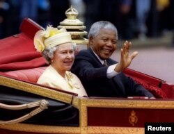 South African President Nelson Mandela is accompanied by Britain's Queen Elizabeth II in a carriage ride to a Buckingham Palace lunch on the first day of his state visit to Britain July 9, 1996.