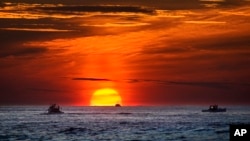 Lobster fishermen are already at work as the sun rises over the Atlantic Ocean, Thursday, Sept. 8, 2022, off of Kennebunkport, Maine. (AP Phot6o/Robert F. Bukaty)