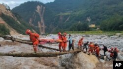 In this photo released by Xinhua News Agency, rescuers transfer survivors across a river following an earthquake in Moxi Town of Luding County, southwest China's Sichuan Province Monday, Sept. 5, 2022.(Cheng Xueli/Xinhua via AP)