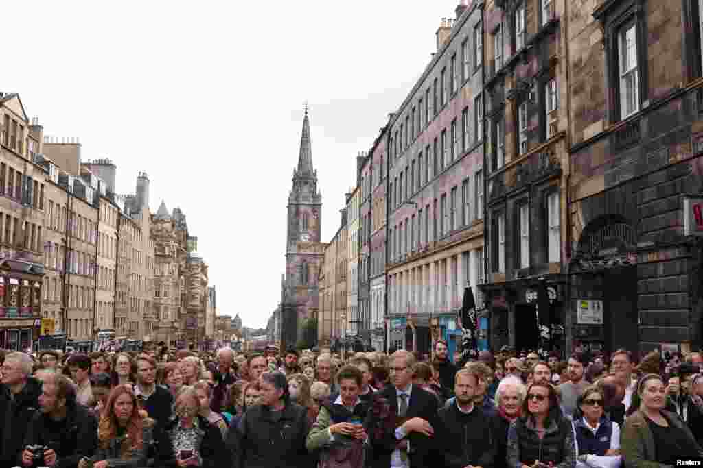 People gather at The Royal Mile as they wait for hearse carrying the coffin of Britain's Queen Elizabeth in Edinburgh, Scotland, Sept. 11, 2022. 