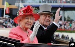 FILE - In this June, 16, 2011 file photo Britain's Queen Elizabeth II with Prince Philip arrive by horse drawn carriage in the parade ring on the third day, traditionally known as Ladies Day, of the Royal Ascot horse race meeting at Ascot, England.
