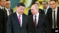 Presiden Vladimir Putin, kanan, dan Presiden Xi Jinping memasuki aula untuk pembicaraan di Kremlin di Moskow, Rusia, 5 Juni 2019. (Foto: AP)