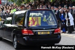 Les gens s'alignent dans la rue alors que le corbillard transportant le cercueil de la reine Elizabeth de Grande-Bretagne traverse le village de Ballater, près de Balmoral, en Écosse, en Grande-Bretagne, le 11 septembre 2022.