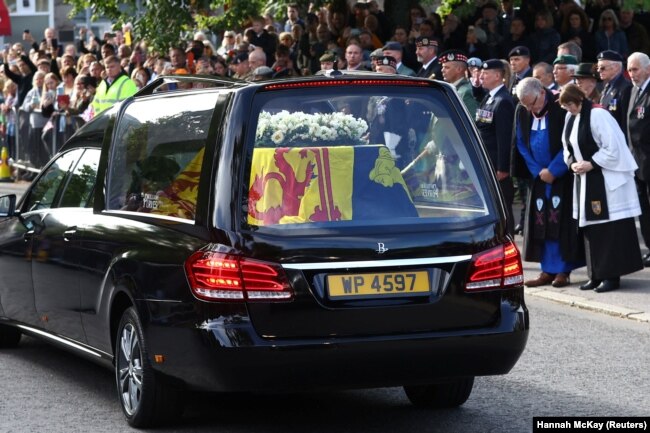 Les gens s'alignent dans la rue alors que le corbillard transportant le cercueil de la reine Elizabeth de Grande-Bretagne traverse le village de Ballater, près de Balmoral, en Écosse, en Grande-Bretagne, le 11 septembre 2022.