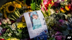 Floral tributes and a farewell message to Queen Elizabeth II are seen outside Holyrood Palace in Edinburgh, Scotland, Sept. 10, 2022.