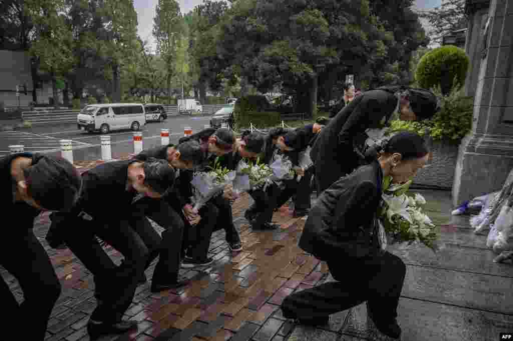 Members of a dance company lay flowers outside the British Embassy following the death of Queen Elizabeth II, in Tokyo, Japan.