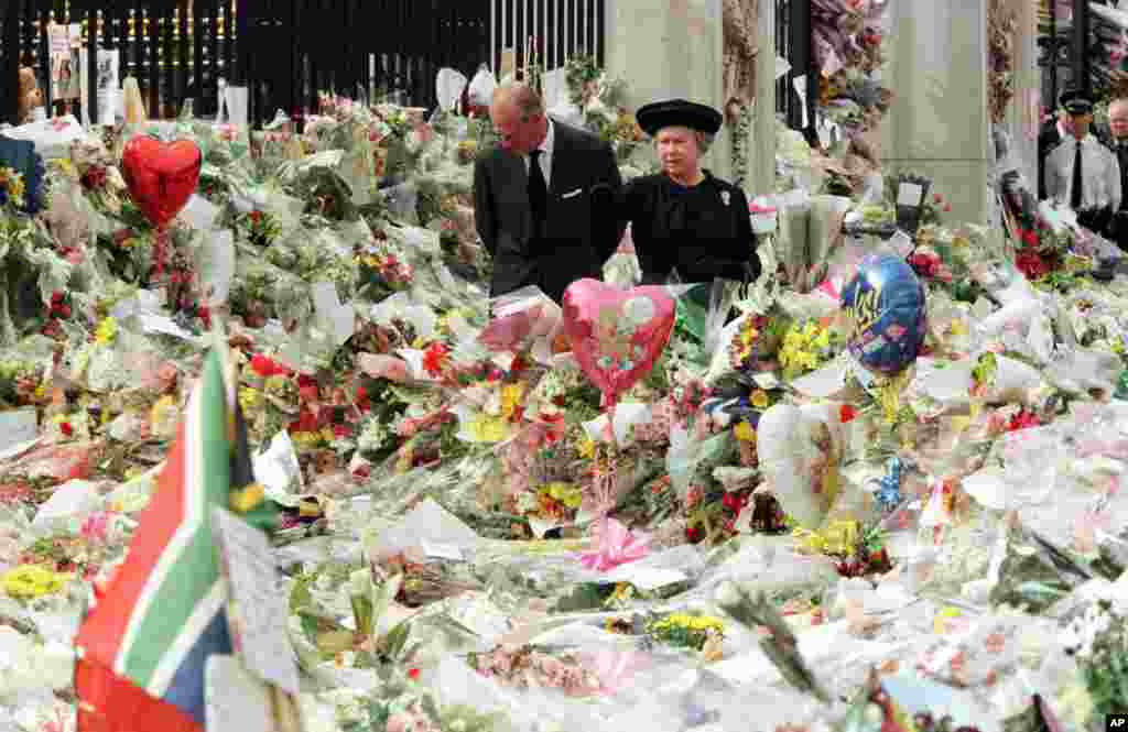 Britain's Queen Elizabeth II and Prince Philip view the floral tributes to Diana, Princess of Wales, at London's Buckingham Palace, Sept. 5, 1997. 