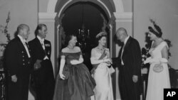 El presidente de Estados Unidos Dwight Eisenhower (1890 - 1969) recibe a la monarca británica en una fiesta de gala ofrecida en la Casa Blanca el 19 de octubre de 1957. Isabel II es acompañada por su esposo, Felipe, y su embajador en Washington DC, junto a la primera dama de EEUU.