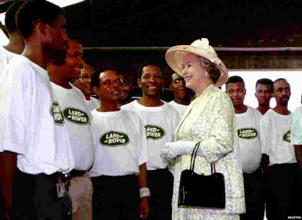 Britain&#39;s Queen Elizabeth II chats with workers at the Landrover factory in the north-west of Pretoria March 24, 1995. The Queen is on a six-day state visit to South Africa