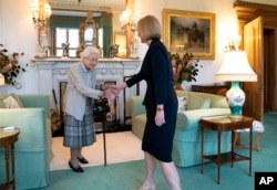 Britain's Queen Elizabeth II welcomes Liz Truss during an audience at Balmoral, Scotland, where she invited the newly elected leader of the Conservative party to become prime minister and form a new government, Sept. 6, 2022.